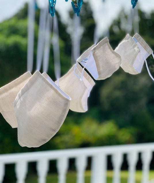 Five Kind Face Masks in Natural Colour Hanging From a Washing Line