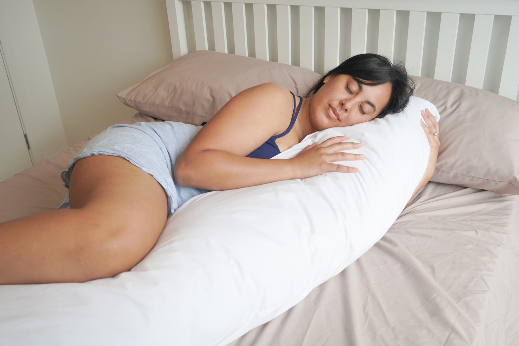 Woman sleeping on a bed cuddling a Kind Face Wool Body Pillow Pregnancy Pillow