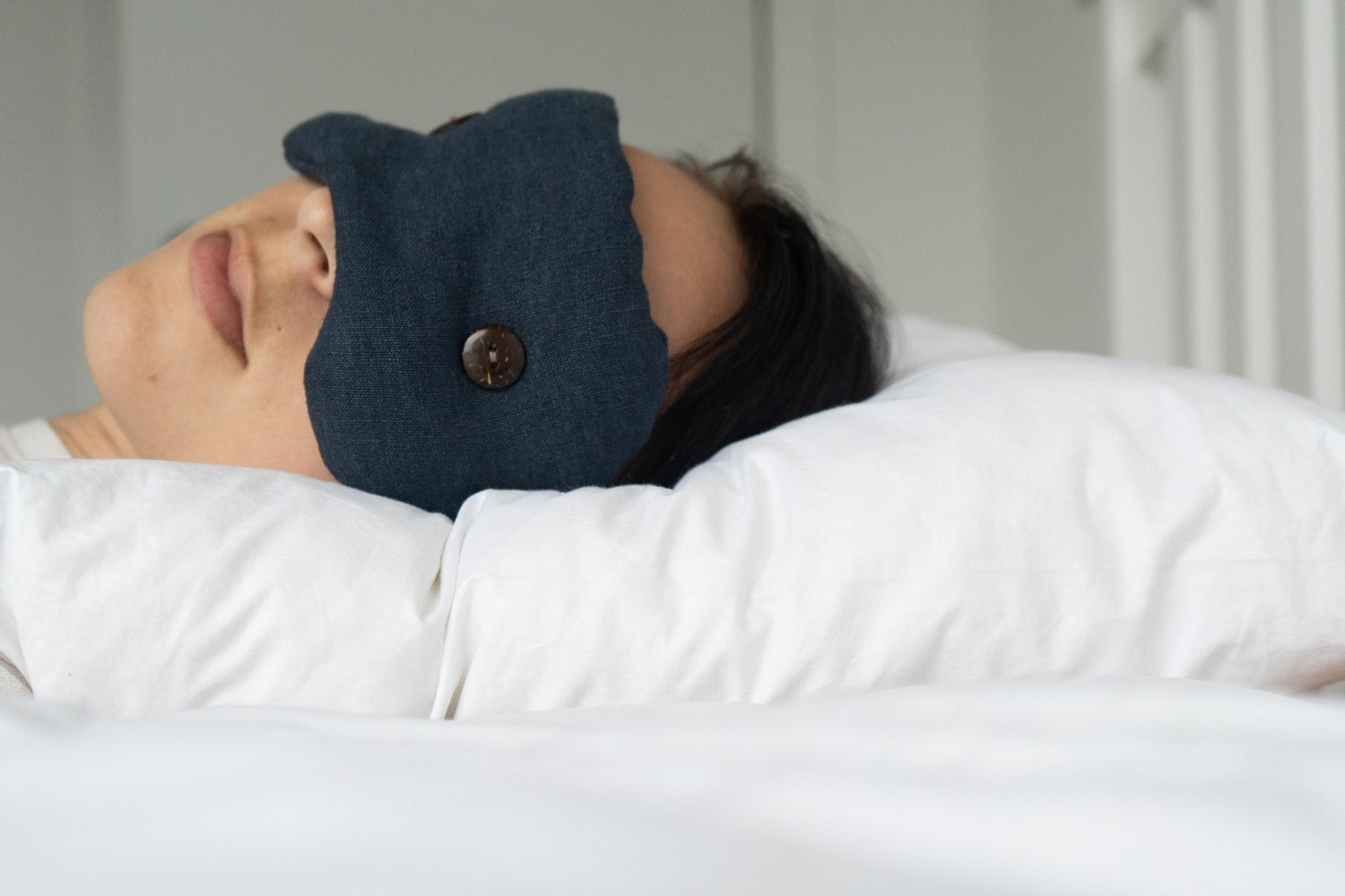 Woman Sleeping on a Kind Face Cloud Wool Pillow wearing a Kind Face Weighted Eye Mask in Ink Colour