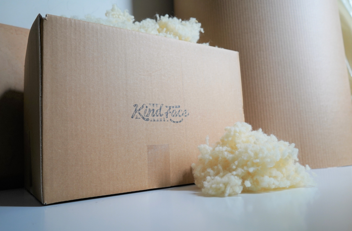 A Kind Face Box with Kind Face Loose Cloud Wool Fill on Top and in Front of it